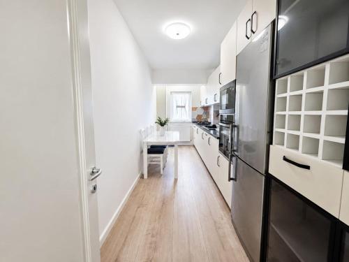 a kitchen with white cabinets and a black refrigerator at Abel 24 Residence in Bacău