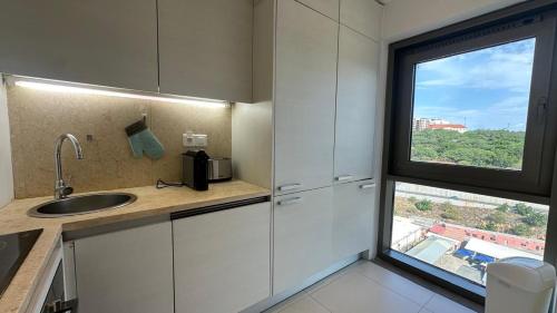 a kitchen with a sink and a large window at Edifício Kings Tower T2-02 in Luanda