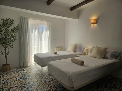 two beds in a room with a window at Villa Palmer in Paguera