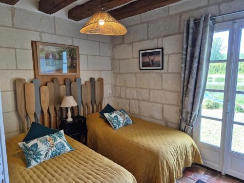 a bedroom with two beds and a window at Le port des Chalands meublé de tourisme 3 étoiles in Saint-Georges-sur-Cher