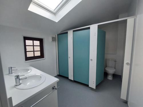 a bathroom with two sinks and a toilet at Cwm Clyd Longhouse in Llanwrthwl