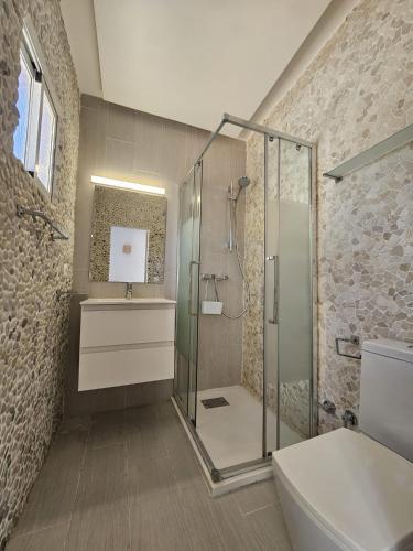 a bathroom with a shower and a toilet and a sink at Villa Palmer in Paguera