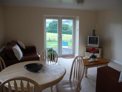 a living room with a table and a couch at Shallcross Hall Cottage - Toddbrook - Whaley Bridge in Taxal