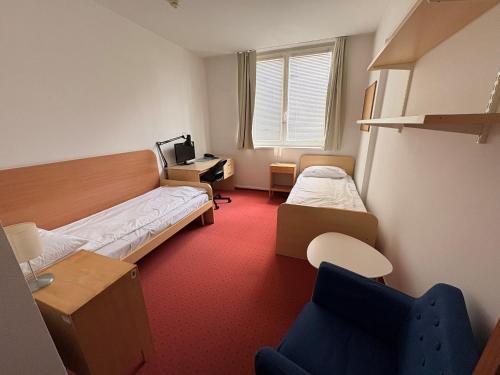 a small room with two beds and a desk at CEU Konferencia Központ in Budapest