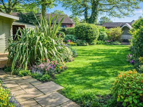 a garden with flowers and plants in a yard at Starboard Cottage in Winterton-on-Sea