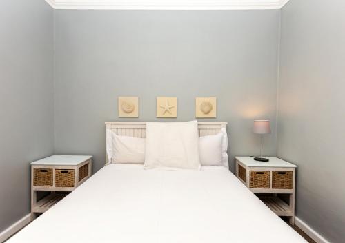 a bedroom with a white bed with two night stands at Helios House in Langebaan