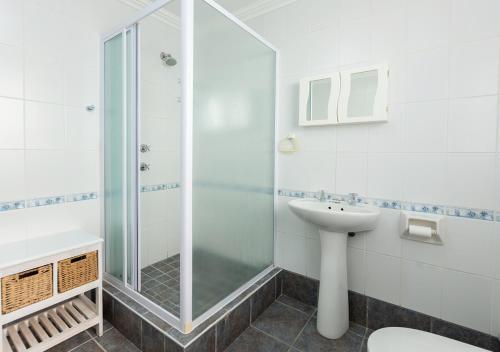 a bathroom with a shower and a sink at Helios House in Langebaan