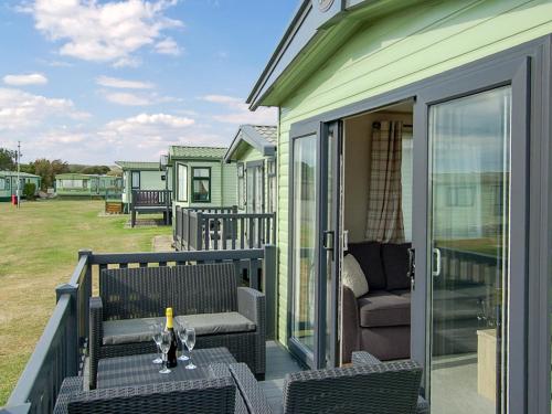 a patio with a table and chairs on a porch at Premier Caravan 10 in Tywyn
