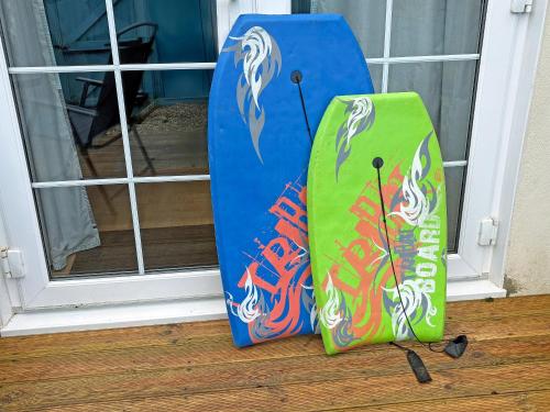 two surfboards sitting on the floor in front of a door at Twenty One in Westward Ho