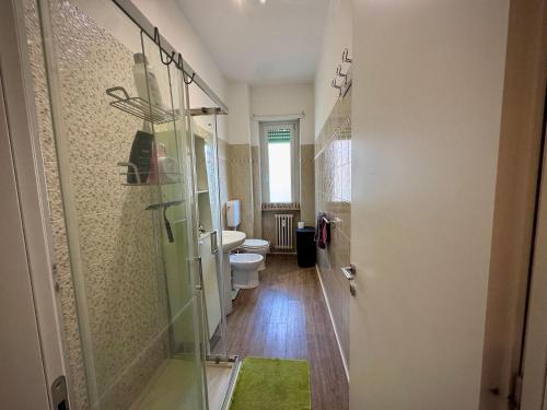 a bathroom with a glass shower and a toilet at Dora Flow in Banchette