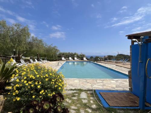 a swimming pool with chairs and flowers in a yard at Holiday Home Le Terrazze del Geco Bungalow B - SLR301 by Interhome in San Lorenzo al Mare