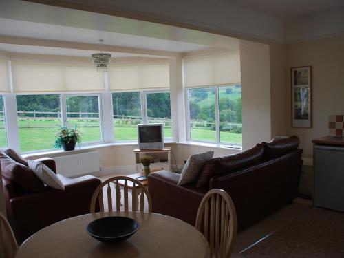 a living room with couches and a table at Shallcross Hall Cottages - Combs in Taxal