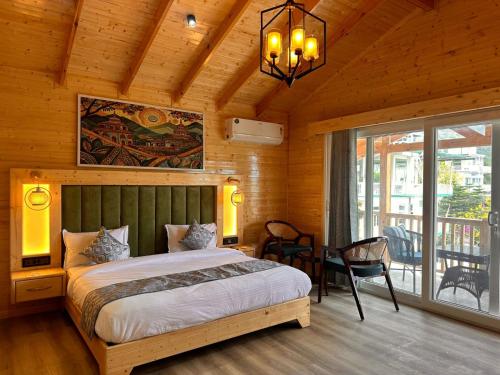 a bedroom with a bed and a chandelier at The Walnut Homes- Luxury Pine Cottages in Bhīm Tāl