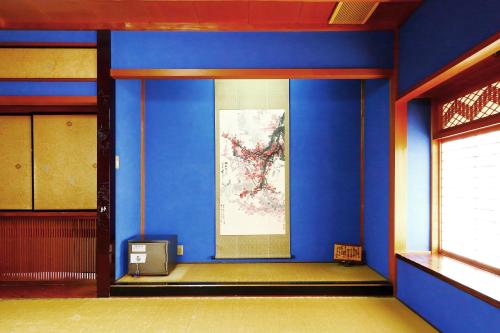a blue room with a painting on the wall at Ryokan Karasawa in Kanazawa