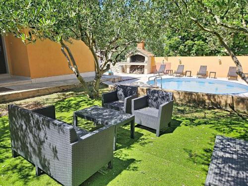 a yard with chairs and a swimming pool with a table at Holiday Home Gorana by Interhome in Mirce