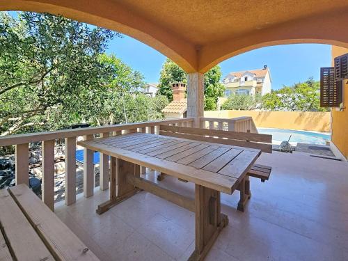 a wooden bench on a porch with a table at Holiday Home Gorana by Interhome in Mirce