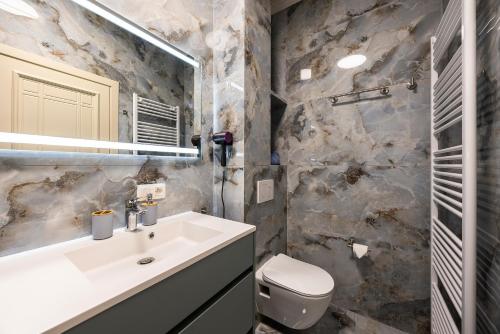 a bathroom with a sink and a toilet and a mirror at GemStay Antwerp in Antwerp
