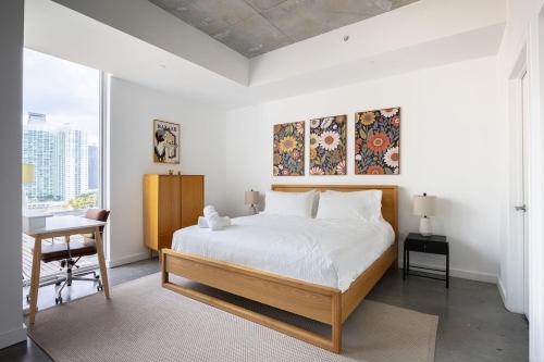 a white bedroom with a bed and a desk and a desk at Stylish Pool Stay Near Brickell & Beach in Miami