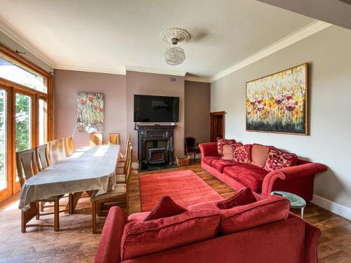 a living room with two red couches and a table at Olveston in Llandudno