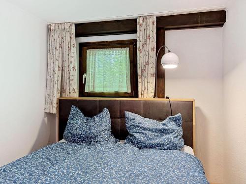 a bedroom with a bed with blue pillows and a window at Apartment Fliederweg by Interhome in Siegsdorf