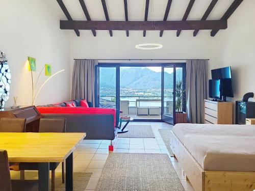 a bedroom with a bed and a couch and a table at Apartment Residenza Miralago Apt- C27 by Interhome in Piazzogna