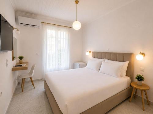 a bedroom with a large white bed and a table at Olive Tree-Member of My Villas Hospitality in Lefkada