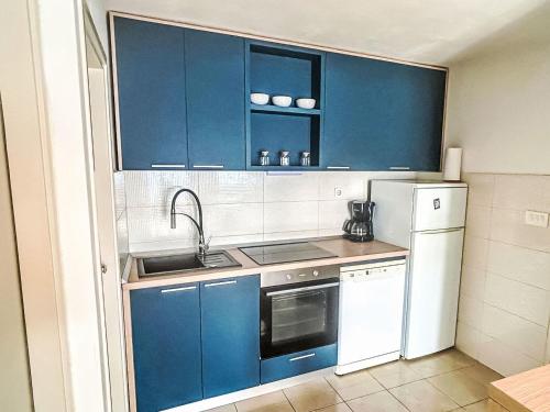a kitchen with blue cabinets and a sink and a refrigerator at Apartment Renata by Interhome in Barić Draga
