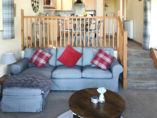 a living room with a blue couch and a table at The Brae Steading in Fordyce