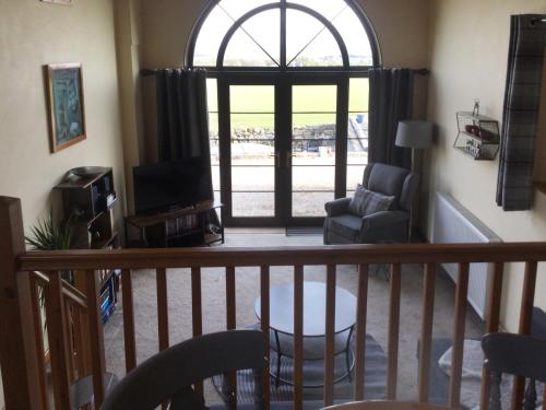 a living room with a large window and a chair at The Brae Steading in Fordyce