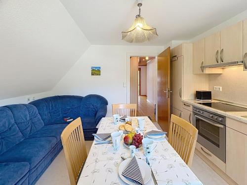 a living room with a table and a blue couch at Apartment Fischer by Interhome in Eisenbach