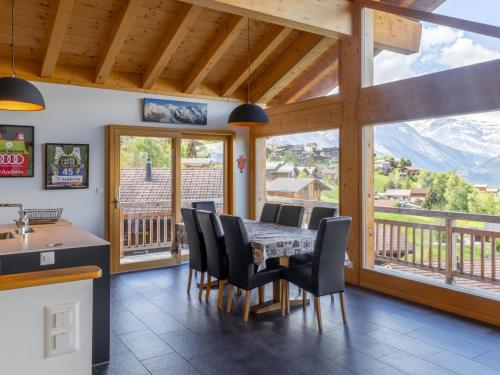 a dining room with a table and chairs and a large window at Chalet D'Arby by Interhome in Nendaz