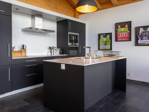 a kitchen with black cabinets and a kitchen island at Chalet D'Arby by Interhome in Nendaz