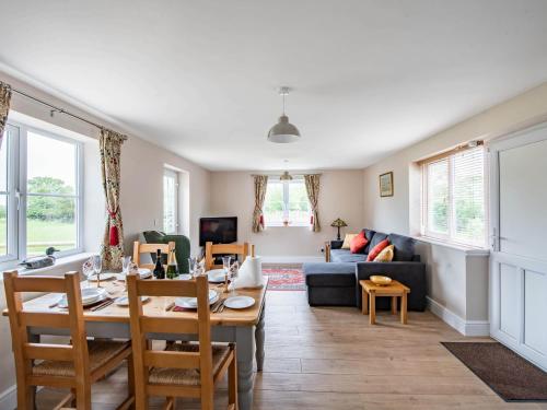 a living room with a table and a couch at Orchard Barns in North Nibley