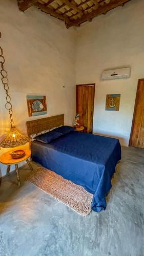 a bedroom with a blue bed and a table at Casa Monã in Maceio
