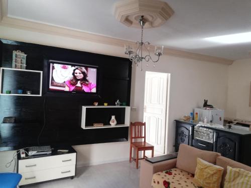 a living room with a tv on a black wall at Luxury in El Haouaria