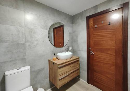 a bathroom with a sink and a mirror and a toilet at Habitación dentro de la Muralla de Lugo 1.3 B in Lugo