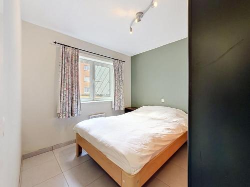 a bedroom with a bed and a window at Apartment Westhinder with balcony by Interhome in Blankenberge