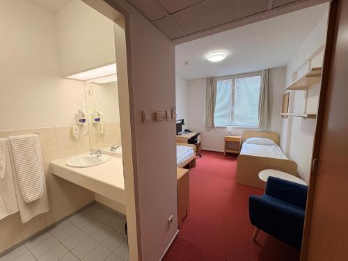 a hotel room with a bathroom with a bed and a sink at CEU Konferencia Központ in Budapest