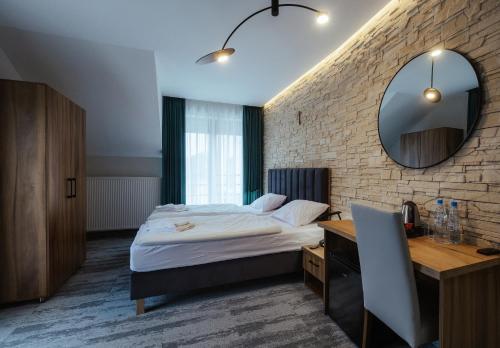a bedroom with a bed and a desk and a mirror at Przystań Leśniów in Żarki