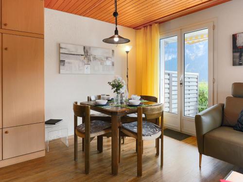 a dining room with a table and a couch at Apartment Chalet Albi-2 by Interhome in Grindelwald