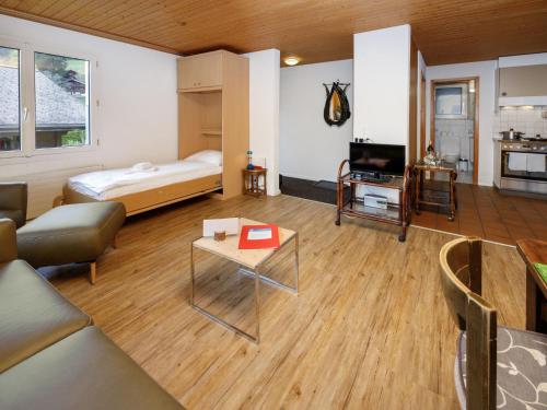a room with a bed and a couch and a table at Apartment Chalet Albi-2 by Interhome in Grindelwald