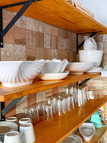a shelf filled with plates and bowls and glasses at Casa Monã in Maceio