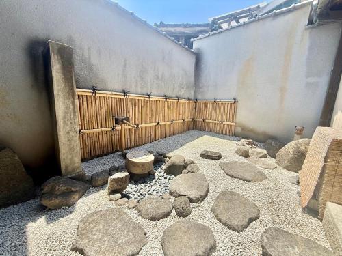 a courtyard with rocks and benches and a wall at Sanada Maru - Entire traditional Japanese house in Kaizuka