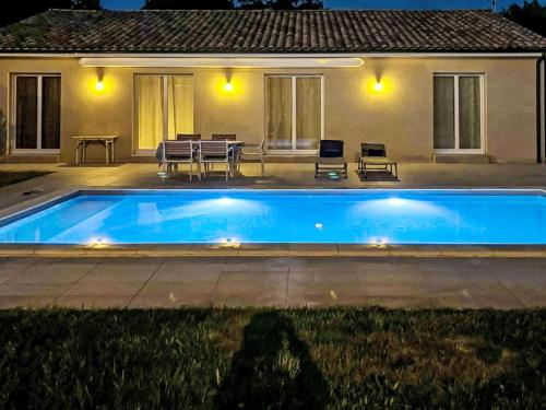 a swimming pool in front of a house at night at Holiday Home Philibert by Interhome in Carcans