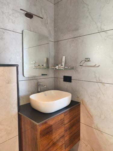 a bathroom with a sink and a mirror at Coorg Tiger Eye Backwater Resort in Kushālnagar