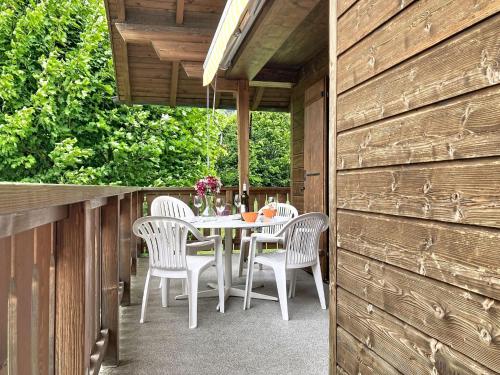 a patio with a table and chairs on a deck at Apartment Chalet Clairval by Interhome in Charmey