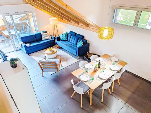 a living room with a table and a blue couch at Apartment Momento by Interhome in Kandersteg