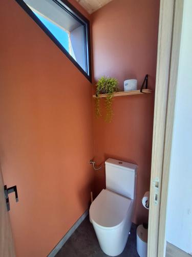 an orange bathroom with a toilet and a window at Domaine Plan Bois in Ballaison