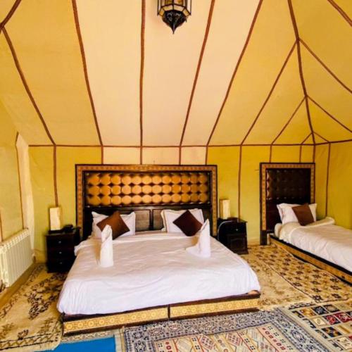 a bedroom with a large bed in a tent at Sunset Dunes Luxury Camp in Merzouga