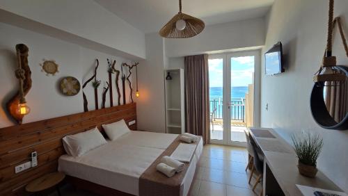 a bedroom with a large bed and a balcony at Edelweiss Rent Rooms-Rent a Car in Tsoutsouros